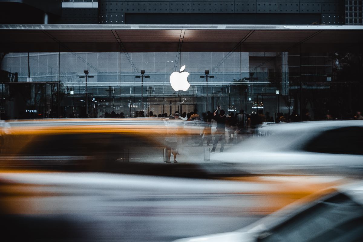 A picture of an Apple headquarters with blurred, moving cars in the foreground
