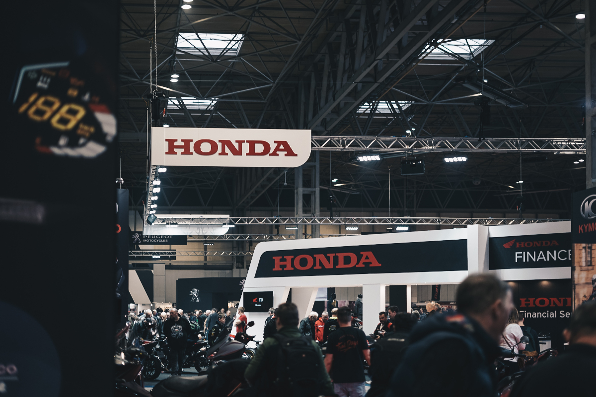 An image of a Honda convention full of people and motorcycles