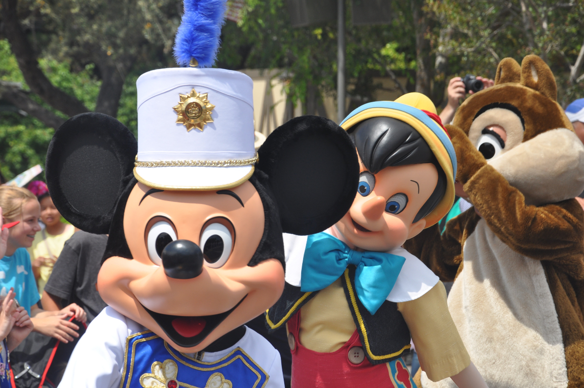 Disney character performers Mickey, Pinnochio, and Chip pose for the camera.