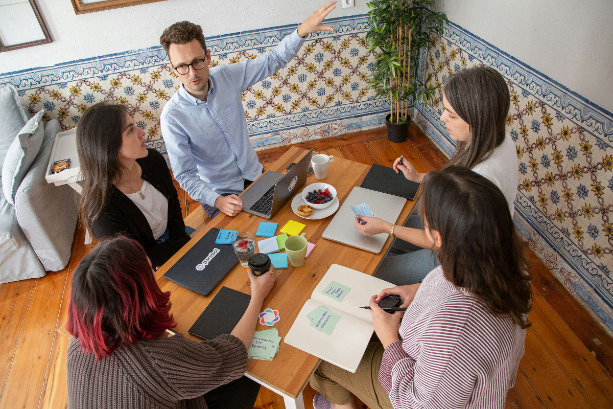 A group of employees sit around a table during a GTM alignment meeting.