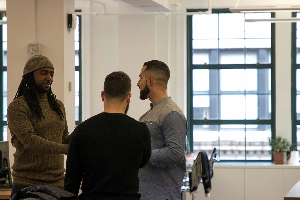 Two men listen as another man uses SPIN selling techniques to build relationships with these leads.