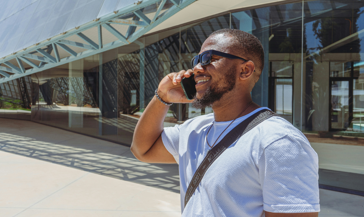 A Black man with short black hair interacts with customers during an outbound customer discovery call.