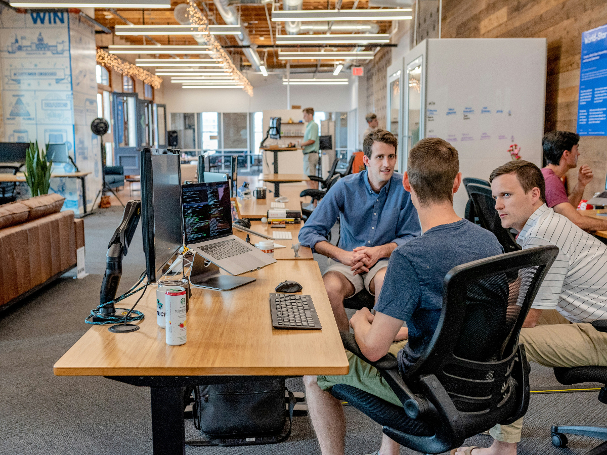 Two white men use conflict resolution skills to problem-solve with the help of a mediator.
