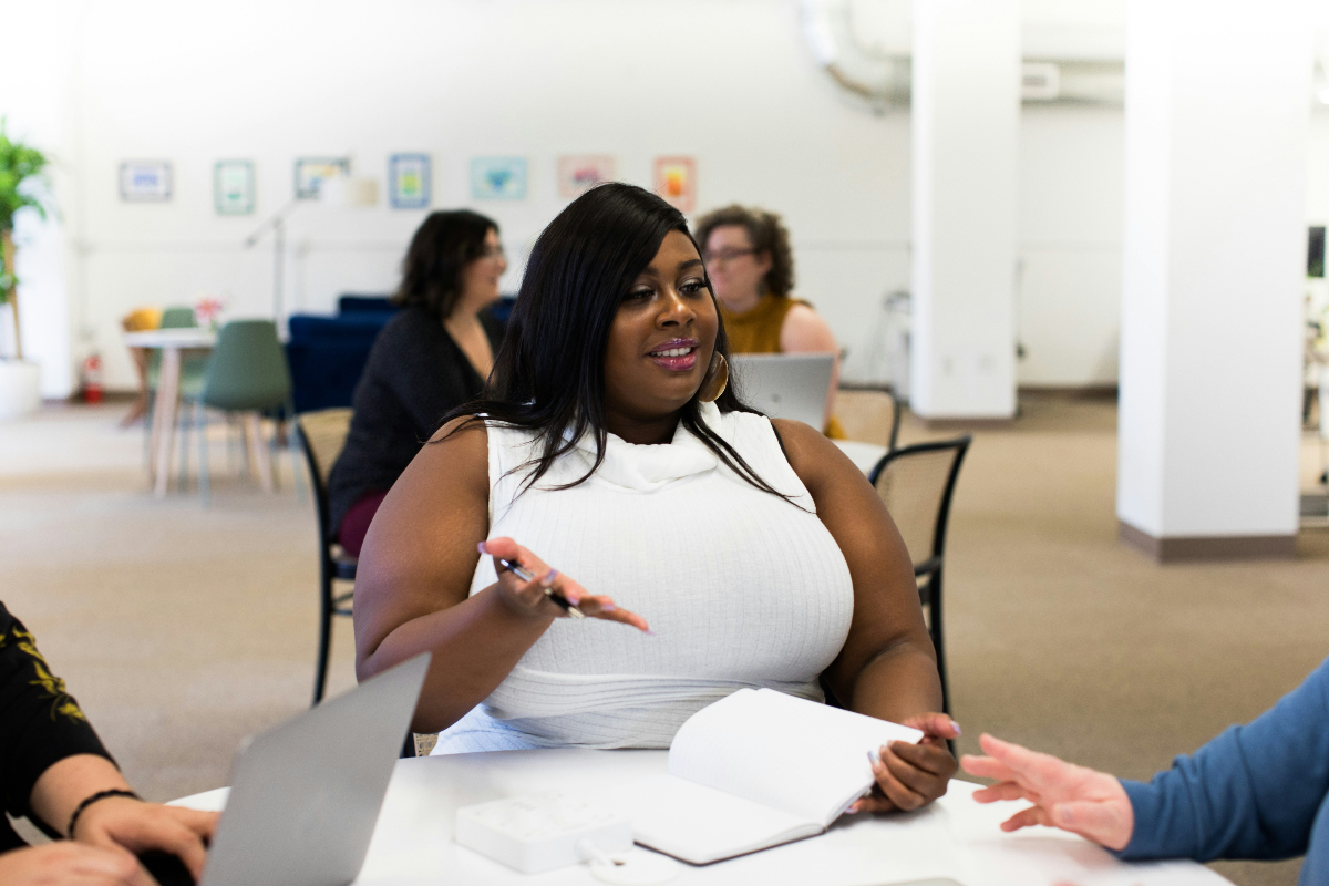 A Black woman with long, black hair wearing a white T-shirt uses lead generation skills to find new prospects.