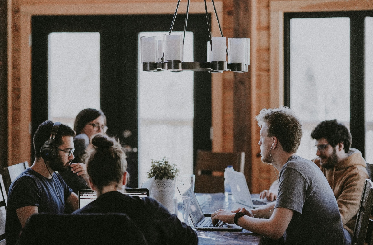 A team sits around a table and engages in roleplays for tech companies to improve their skills