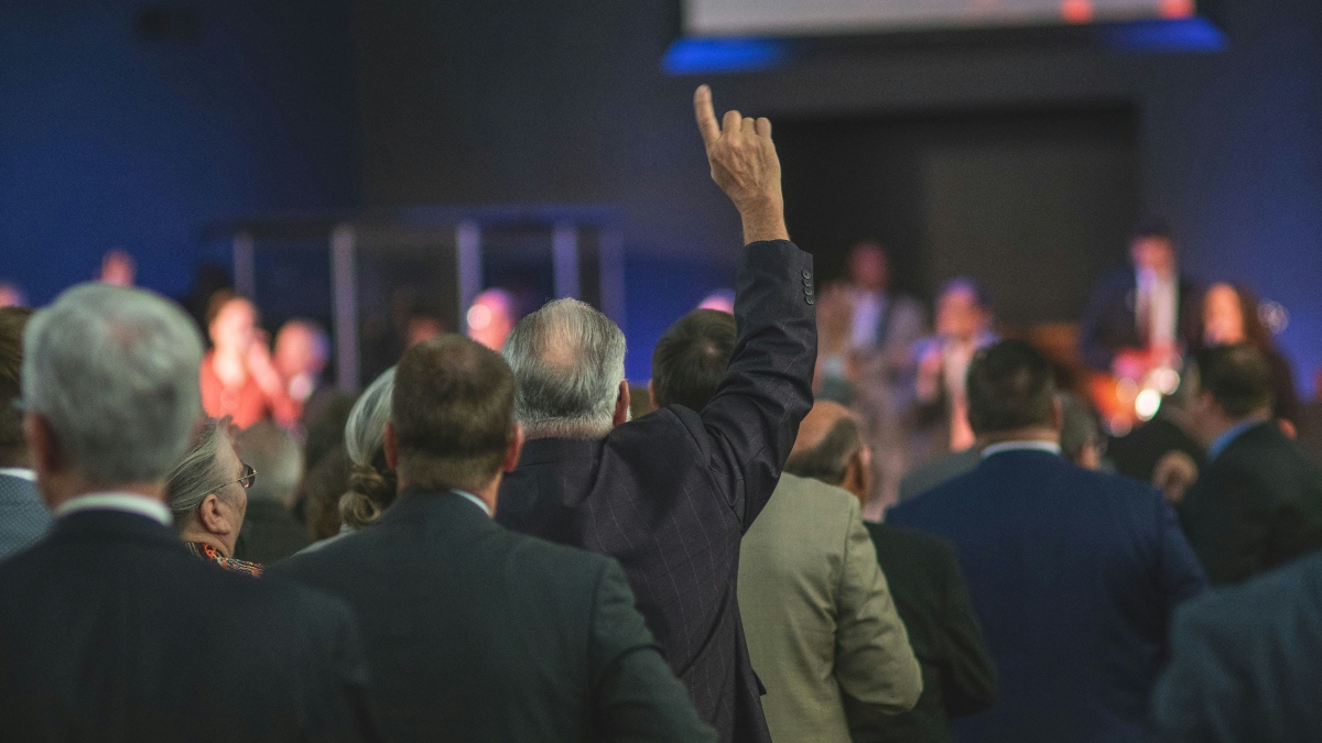 A man raises his hand at a press conference